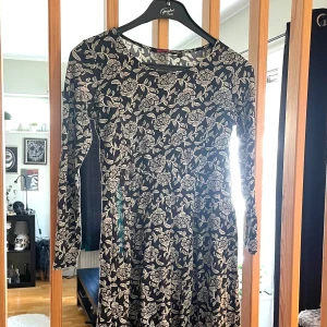 Indiska- Långärmad klänning- Strl M-50% Modal - ljer den här supersköna och snygga långärmade klänningen i strl M från Indiska.  Klänningen är i ett mycket skönt material just pga tygets sammansättning av ren bomull 50% och sedan modal 50%. Inte bara att modal rent ur miljömässig syn är ett självklart val utan för att det hjälper huden att ”andas” genom tyget vilket gör att du aldrig känner den där instängda, varma känslan du kan få av vissa tyger. Det är känt för sin mjukhet, silkeslena känsla och goda fuktabsorberande förmåga.