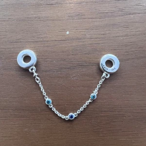Säkerhetskedja till Pandora armband - Säkerhetskedja med blåa stenar i silver till Pandora armband. Så gott som nytt. Använt färre än 10 gånger. (Armband ingår ej i priset)