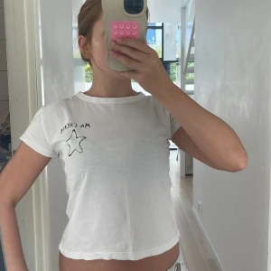 Vit t-shirt Ma Chérie 🤍 - Vit t-shirt från Gina Tricot med svart tryck 'MA CHÉRIE' och en stjärna på bröstet och ryggen. Modellen är kortärmad och har en klassisk rund hals. T-shirten är i mjuk bomull och har en clean, enkel vibe.🩶🤍