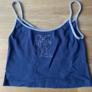Mörkblå linnetopp med ängeltryck - Supersöt mörkblå linnetopp från Brandy Melville. Använd et fåtal gånger. Materialet känns mjukt och skönt mot huden. Skriv via dm vid funderingar 