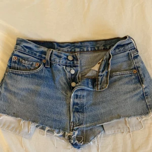 Levi's ljusblå jeansshorts med fransar - Säljer ett par ljusblå jeansshorts från Levi's. Storlek S. Low/ mid waist. Slitningar. Finns tecken på användning. 