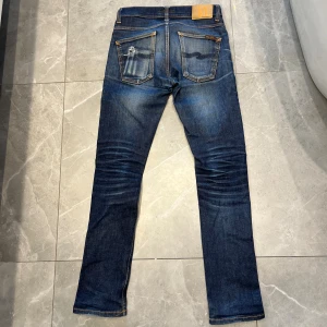 Nudie jeans - Säljer dessa nudie jeans med sjukt snygga fades! Står 30/32 på tagen men sitter som 28/32. Dom är i bra skick förutom att de har ett litet hål i grenen som inte märks av och hål i framfickan vilket kan fixas. Skriv vid minsta fråga/fundering👌