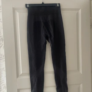Svarta höga leggings - Svarta leggings med hög midja och tight passform. De är stretchiga och mjuka, perfekta för att chilla eller träna i. Materialet känns lent mot huden och de sitter riktigt snyggt på kroppen.