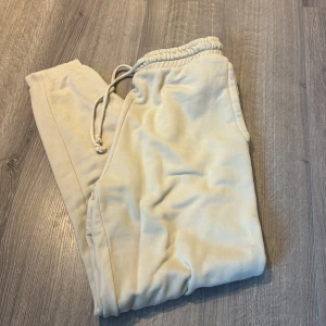 Beige mjukisbyxor från Pull&Bear XS - Säljer ett par beige mjukisbyxor från Pull&Bear i storlek XS. Byxorna har resår och snörning i midjan samt muddar vid bensluten. Perfekta för chill dagar och riktigt sköna tack vare det mjuka bomullsmaterialet.
