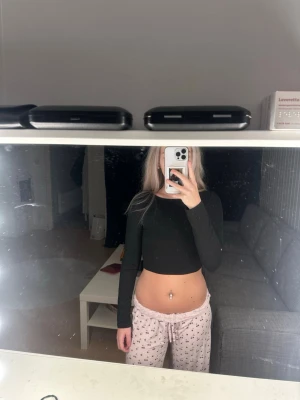 Svart croppad topp med öppen rygg - Säljer en svart croppad långärmad topp med öppen rygg och snygga snörningsdetaljer bak. Toppen är knappt använd så i väldigt fint skick. Storlek S  