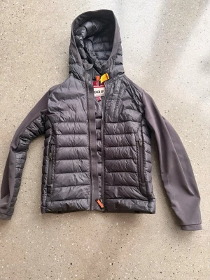 Parajumper jacka - Parajumper kinari cardigan som nu säljs pga att jag har växt ur den. Jag skulle säga att den passar runt 12 år och är storlek Y-M. Har lagats 1 gång med original tyg hos professionelle skräddare