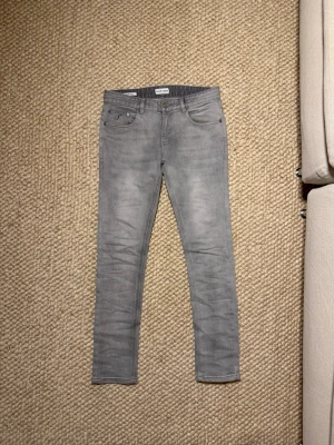 Grå skinny jeans från Dr. Denim - Snygga grå slim jeans från ett Sammarbete. Med klassisk femficksdesign och smal passform. Jeansen har en stilren look med diskreta sömmar och är tillverkade i stretchigt jeanstyg för extra komfort. Storlek 30 sitter lite litet på mig nu. Mvh Grischelino🙏