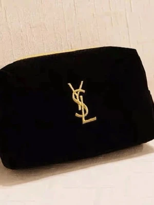 Svart kuvertväska från Yves Saint Laurent - Stilren svart kuvertväska från Yves Saint Laurent med klassisk guldlogga framtill. Väskan har en enkel, rektangulär form och är tillverkad i mjuk sammet som ger en lyxig känsla. Perfekt accessoar för att lyfta din outfit.