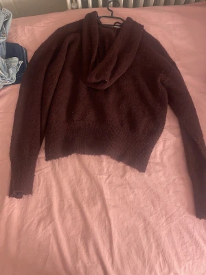 Vinröd hoodie från Gina Tricot - Mysig vinröd hoodie från Gina Tricot i mjukt, fluffigt material. Hoodien har en avslappnad passform, lång ärm och en stor huva. Perfekt för dig som gillar en chill och bekväm stil.