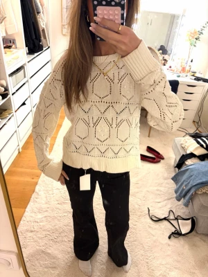 Vit stickad tröja med mönster - Snygg vit stickad tröja med  hålmönster och ribbade muddar. Tröjan har rund halsringning och avslappnad passform🩵🩵🩵
