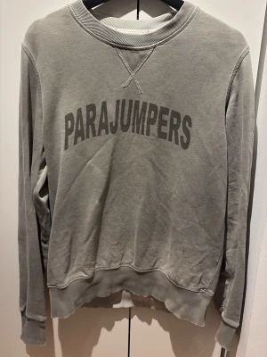 Parajumper tröja  - Säljer denna riktigt snygga parajumper tröjan i en stilren ljusgrön färg, är mellan S och M i storlek. Finns en liten uttvättad fläck som knappt syns i vardagen, därav det sänkta priset. Hör av dig vid frågor eller fler bilder!
