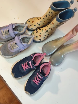 Skor paket 29/30 - Ett paket med barnskor och stövlar med Disney-tema. Inkluderar ett par gråa sneakers med kardborreband och motiv, ett par mörkblå sneakers med rosa detaljer och motiv, ett par gula gummistövlar med Mickey Mouse motiv och ett par rosa/gråa gummistövlar .Kolla gärna mina andra annonser.