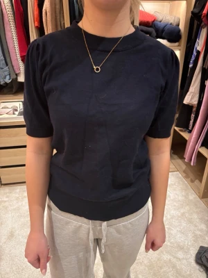 Svart topp från Saint Tropez - En enkel och stilren svart topp från Saint Tropez med rund halsringning och korta ärmar. Toppen har en normal passform och är tillverkad i mjukt material som känns skönt mot huden. Perfekt att matcha med jeans eller kjol för en clean look.