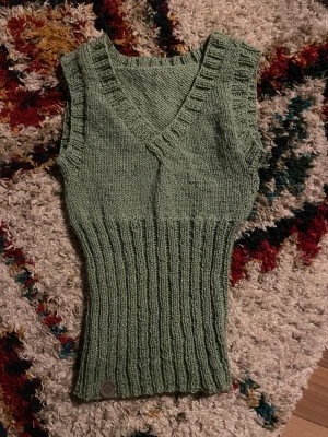 Stickad väst - Väst i akryl och bomullsgarn som jag stickat själv. Sitter åt om kroppen men är stretchigt. Värmer otroligt skönt. 