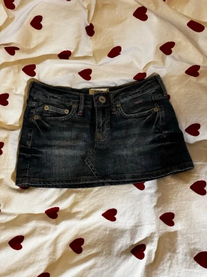 Mini jeanskjol - Söt jeanskjol från BDG med röda sömmar lite här o var, och märke tryckt på högra bakfickan. Använd fåtal gånger, inga defekter. Midjemått: 36cm