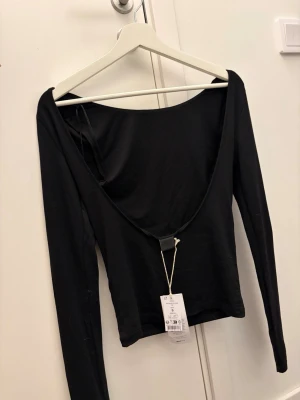Svart långärmad topp med öppen rygg - Säljer denna helt nya svarta toppen med öppen rygg från ginas soft touch kollektion 💗