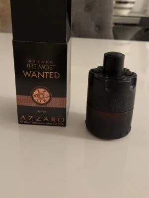 Azzaro The Most Wanted Parfum 100 ML 100ml - Azzaro The Most Wanted Parfum är en herrdoft i en cool, svart och matt flaska med unik cylinderformad design. Flaskan rymmer 100 ml och har detaljer i kopparfärg. Doften är intensiv och maskulin, perfekt för dig som vill sticka ut med en modern och elegant parfym.