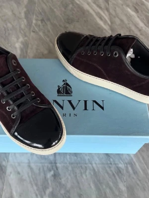 Mörklila sneakers från Lanvin - Snygga mörk röda sneakers från Lanvin. Perfekta för dig som vill ha en stilren och lyxig look med en unik touch.  Storlek 41 men passar 42 |Skick 8/10 nypris ca 4000 mitt pris 1900kr|