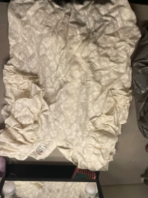 Vit spetsblus med puffärmar - Söt vit blus i spetsmaterial med blommigt mönster och puffiga korta ärmar. Blusen har knappar bak och volangdetaljer vid axlarna. Perfekt för dig som gillar romantisk och trendig stil.