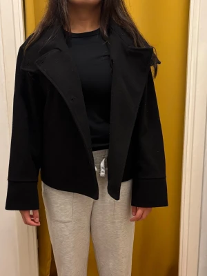 Svart kappa  - Fin kappa från Gina Tricot. Personen på bilden är 157 och väger runt 54 kg för context. Storlek XS. Nypris 399 säljer för 150kr