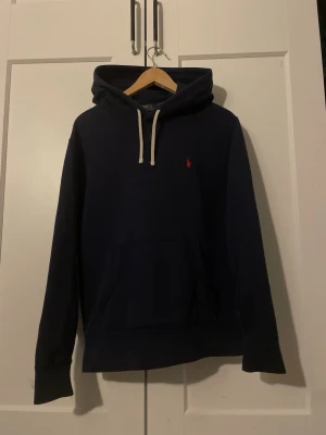 Mörkblå Ralph Lauren hoodie  - Säljer en skön hoodie från Ralph lauren. Tröjan är i bra skick med inga skador. Det är bara höra av er vid frågor och funderingar!😎