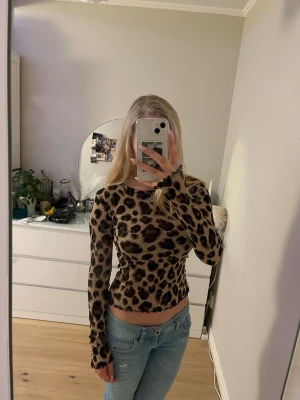 Leopardmönstrad långärmad topp - Säljer en leopardmönstrad långärmad topp från LINDEX. Toppen är tight i modellen, har rund halsringning och är tillverkad i ett mjukt stretchigt material. Nästan aldrig använd därav säljer jag den💗