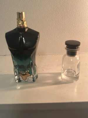 Jean Paul Gaultier Le Male parfym - Säljer en Jean Paul Gaultier Le Male parfym i den ikoniska flaskan formad som en manlig torso. Flaskan är i glas med blå och svarta toner samt gulddetaljer på korken. Perfekt för dig som gillar unika och snygga parfymflaskor.