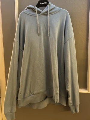 Ljusblå oversized hoodie  - Ljusblå hoodie i oversized modell med huva och dragsnören. Mjuk bomullsmix, ribbade muddar vid ärmslut och nederkant. Perfekt för en avslappnad och trendig stil.