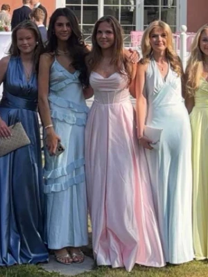 Ljusrosa långklänning med smala axelband och corsett rygg - Så himla fin balklänning som verkligen passar till bal. Den är i satin och har kryssad rygg som är justerbar genom att man drar åt själv. Färgen är helt underbar. Den har lite vaddering vid kuppora och passar någon vi längden ungefär vid 170 cirka. Använd endast en gång.💞