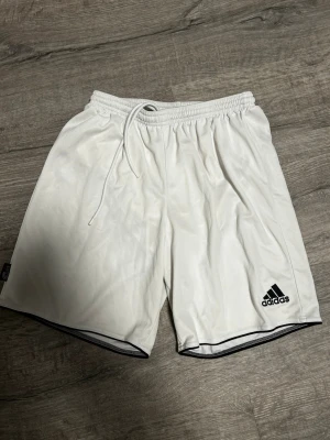 Två Adidas shorts med snörning och inne byxa - Adidasbyxor shorts med snörning vid midjan och logan vid låret.