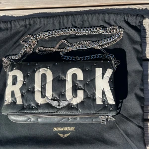 Svart handväska från Zadig & Voltaire - En svart handväska från Zadig & Voltaire med texten ROCK. Kan byta mot annan🩷🩷 synligt slitage!