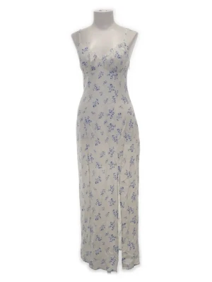 Vit långklänning med blå blommor  - Supersöt långklänning från Amisu i vit med blått blommönster. Klänningen har smala axelband, figurnära passform och en liten slits framtill. Perfekt för sommarens alla tillfällen. Materialet känns lätt och luftigt.