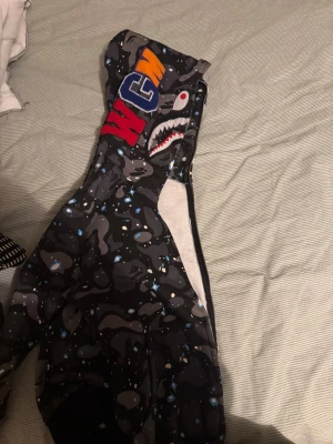 Bape hoodie - Säljer nu en bape hoodie jag fick av en grabb för att jag klippte hans hår. Inga hål eller liknande och är i väldigt fint skick. Som sagt, har NOLL koll på bape och kan inte garantera om varan är äkta eller inte, hur som helst så är den fet (för rätt stil) och gjord i kvalitets material enligt mig. Vid frågor eller funderingar släng iväg ett PM så löser vi det. //mvh MB
