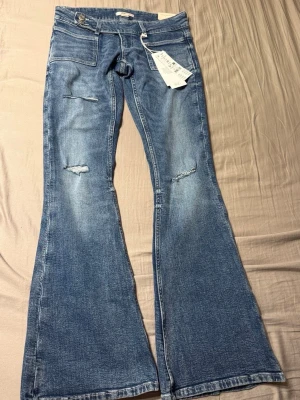Jeans från Gina Young 14+ - Ett par blå lågmidjade bootcut  jeans från Gina Tricot Young 14+ i storlek XS. Dem är helt nya🩷🩷
