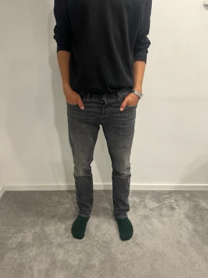 Jack&Jones Jeans  - Säljer ett par mörkgrå Jack&Jones jeans med raka ben och klassisk femficksdesign. Jeansen har en snygg tvättad look och normal passform. Perfekta till en avslappnad stil och funkar året runt. Materialet är slitstarkt jeans och färgen är mörkgrå. W29 L30