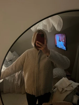 Beige teddyjacka Pernilla Wahlgren XS - Mysig beige teddyjacka från Pernilla Wahlgren i storlek XS. Jackan har dragkedja framtill, två stora fickor och är helfodrad. Perfekt för dig som vill ha en varm och fluffig look med oversized känsla.