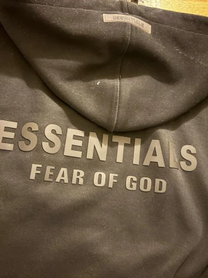 Essentials fear of god hoodie - Säljer en Essentials Fear of God sweatshirt i bra skick. Klassisk modell med tryck framtill. Använd men väl omhändertagen, inga större defekter.  ✔ 100 % original ✔ Skön passform ✔ Populär Essentials-modell  Skickas eller möts upp. Hör av dig vid frågor!