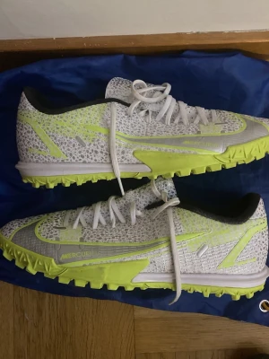 Nike Phantom GX fotbollsskor vit grusskor  - Säljer ett par Nike Phantom GX fotbollsskor i vitt med neon-gula detaljer och sula. Skorna har knappt användst och håller hög kvalité. Pris kan diskuteras 