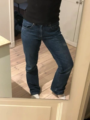 Mörkblå jeans från Boomerang - Säljer ett par klassiska mörkblå jeans från Boomerang. Modellen har normal passform med raka ben och fem fickor. Jeansen är tillverkade i slitstark bomull och har snygga kontrastsömmar samt knapp med Boomerang-logga. Perfekta till vardagslooken.