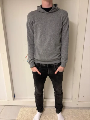 GRÅ KASHMIR HOODIE FRÅN OSCAR JACOBSON - Grå Kashmir hoodie från Oscar Jacobson med en bra slim passform som är i storlek S. Om ni har några frågor så är det bara att skriva till oss.