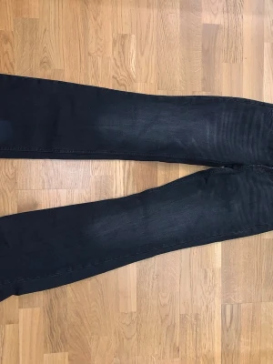 Svarta bootcut jeans med låg midja - Säljer ett par svarta jeans med bootcut-modell och låg midja. Jeansen är från bershka och har svarta sömmar och lätt tvättad look. Materialet är jeans och passformen är normal. Storleken är 32!💕