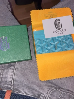 Turkos Go.yard plånbok med mönster - Säljer en snygg turkos plånbok från Go.yard med deras ikoniska grafiska mönster. Plånboken har flera kortfack och levereras i original grön ask och med gul putsduk. Perfekt för dig som vill ha något unikt och stilrent i fickan.