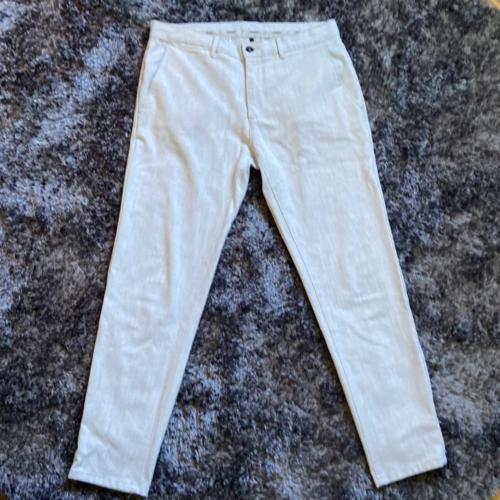 Ett par silver-vita byxor från Zara. Byxorna har en knapp och dragkedja framtill samt fickor på sidorna och baksidan. saknar en knapp på ena bakfickan men annars bra skick. Jeans & Byxor.