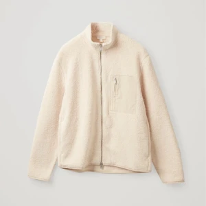 Cos Fleece Zip up beige - En varm och mysig jacka i en ljus beige färg. Jackan har en dragkedja framtill och en ficka på bröstet. Den har en avslappnad passform och är perfekt för kalla dagar.  Size M ( slightlyoversized)