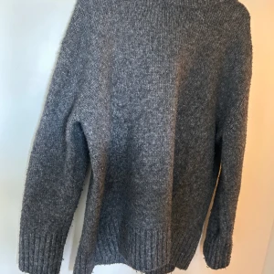Grå stickad tröja Zara - Säljer denna  stickade tröjan från zara då den inte används, storlek M men väldigt långt och mysig.