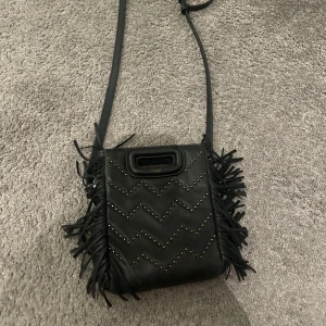 Svart majeväska - Jättefin Majeväska i bra skick som inte används längre! Denna modell säljs inte längre och har stenar på ena sidan och är helsvart på andra. Den är köpt för 4000 och säljer för 1900 ( pris kan diskuteras)