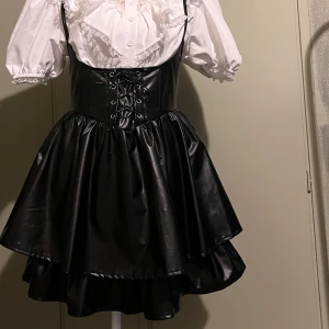 Kjol - Svart skinn imitations kjol med korsett och hängslen.🖤 användes till en miss Misa cosplay men inte efter det.  Superfint skick. Blus medföljer EJ. Märket är Romwe Storlek: M, passar även mindre🖤