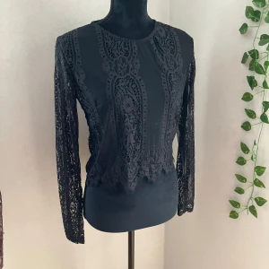 Svart spetstopp/spetsblus - Ny oanvänd genomskinlig spetstop/spetsblus. Ser mycket finare på kroppen! Från Bik Bok.