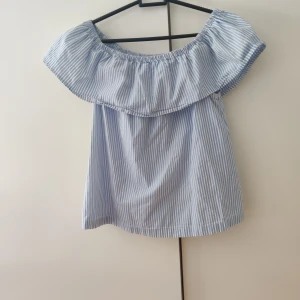 Gullig topp  - Säljer en gullig topp med volanger som är randig🤍💙. Går att ha vanligt eller off shoulder. Skriv för fler bilder