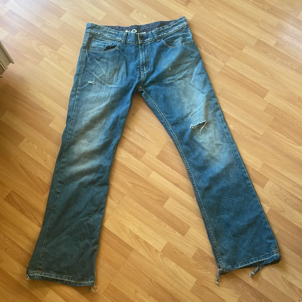 Bootcut vintage jeans med skador längst ned vid fötterna . Jeans & Byxor.